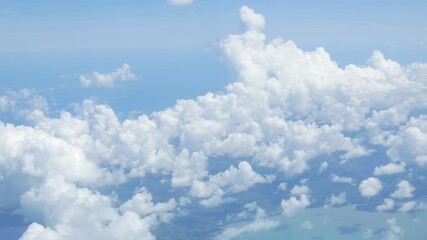 Wall Mural - view from plane over blue sky with white Fluffy clouds while flying through in sunny summer time.nature blue sky cloud and sun for Clean Environment, save energy or transportation holiday concept. 