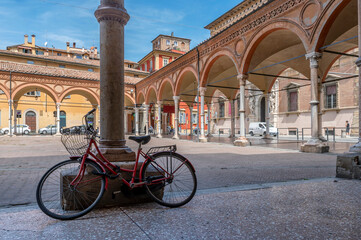 A bicycle is leaning against one of the columns that embellish the facade of the Basilica of Santa Maria dei Servi, Bologna, Italy