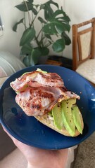 Hearty Breakfast Open Sandwich: A delicious and healthy breakfast sandwich with bacon, avocado, and chilli flates on a toasted bun.