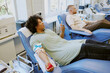 © AnnaStills - People reclined donating blood in medical facility, holding stress balls in arms Relaxing on chairs with medical equipment surrounding them, giving blood in safe and sterile environment