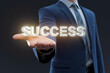 © Fatima Abdul Moiz - Businessman holds glowing SUCCESS, symbolizing achievement and prosperity
