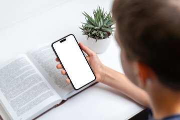 Poster - Child holding phone beside a book, isolated screen display ideal for mockups and app presentations. Perfect for tech, learning, education, and digital content visuals