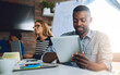© peopleimages.com - Reading, tablet and business man in startup meeting for planning development project in office. Happy worker, digital technology and research online for editing creative blog, article and coworking