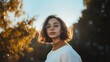 © Postmodern Studio - Woman with glasses and a short haircut is standing in front of a tree