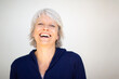 © Paula - Smiling mature woman in navy blue jacket against white background