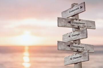 corporate competence courage consistency character text quote written on wooden sign outdoors by the sea