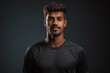 © Markus Schröder - Portrait of a content indian man in his 20s sporting a breathable mesh jersey in blank studio backdrop