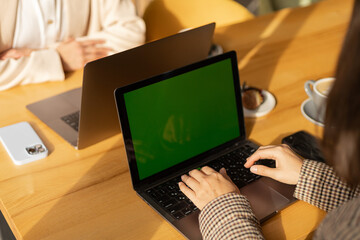 coworking space, female hands work at two laptops