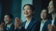 © David Zarzosa - Smiling Woman Applauding at Business Conference with a diverse audience.