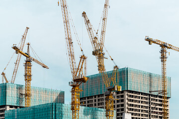 busy construction site with crane towers and unfinished buildings.