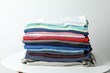 © Sunlight - A stack of freshly washed, neatly folded clothing on a wooden table