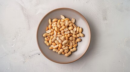 Poster - Top view of a simple plate filled with shelled peanuts, with the clean background providing a stark contrast that emphasizes the peanuts' natural color