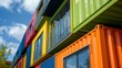 © Justlight - Low angle view of an apartment building constructed using recycled shipping containers, showcasing a modern and sustainable approach to urban living