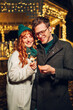 © Zamrznuti tonovi - A festive couple hugging and celebrating christmas eve on a street.