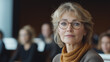© Madlen Gray - Middle-aged woman listening attentively at business conference