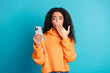 © deagreez - Photo of pretty impressed teen lady dressed orange turtleneck reading news modern gadget empty space isolated blue color background