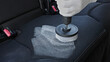 © Pavel - Professional car cleaning. Worker uses professional brush tool to clean car seat upholstery leaving a foam trail. Advertising concept for professional car cleaning. Copy space. Backdrop.
