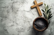 © vejaa - Religion, faith, liturgy, Ash Wednesday, Lent background. Brown wooden cross, ceremonial ash bowl and olive branch on grunge gray background