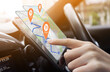 © hakinmhan - Person using  GPS navigation app on a smartphone in a car, with food location pins displayed on the screen. Ideal for concepts of technology in travel, food delivery