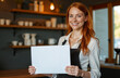© Kate - red-haired happy smiling girl barista waiter standing with a mockup in her hands