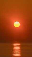 Wall Mural - timelapse of dramatic sunrise with orange sky in a cloudy day at the ocean.