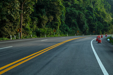 Wall Mural - long curvy forest asphalt road over the hills. beautiful curved road in the forest. side view of roa