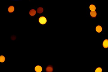 Many soft orange, yellow and red blurry bokeh light on dark background in Christmas and New Year festival day, can use for background, have copy space