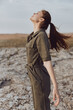 © SHOTPRIME STUDIO - Woman standing in the desert with arms raised in the wind, embracing the beauty of nature