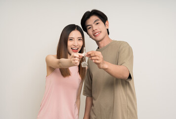 Wall Mural - Happy family asian couple attractive in various action gesture holding house key on isolated white background. Cheerful Smiling young man and woman buy new home showing key of the house