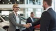 © yj - A female dealer in a car store shakes hands after successfully signing a contract with a male customer.