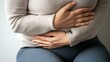 © zen - Close-up of a womanâ€™s hands gently resting on her toned stomach, emphasizing fitness and wellness, with a focus on her midsection on a neutral gray studio background, leaving ample space for