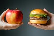© khalid_spk - One hand holding apple fruit, other holding hamburger. Healthy natural organic fresh