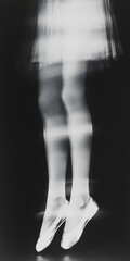 A close-up, artistic black and white photograph of a dancer's feet in ballet shoes, emphasizing the elegance and strength of movement.