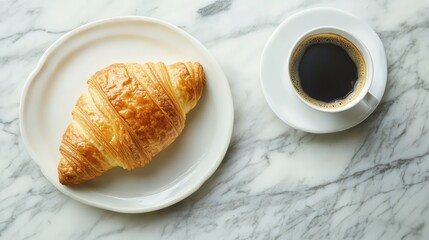 Poster - On a marble table, a croissant is served with coffee for breakfast