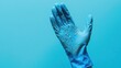 © Mehemmed - Hand wearing a blue rubber dishwashing glove, displaying grit from the washing process. Capture the detail of the glove and a blank space for added context in the composition.