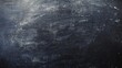© Sinechana - 2410 43.A close-up of a textured chalkboard with faint chalk residue and smudges, creating a rough yet clean black surface. The dark background is simple and open, providing a perfect space for