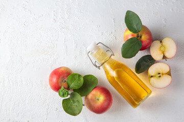 Wall Mural - Apple cider vinegar of fermented fruit into a glass bottle with fresh organic ripe red apples with leaves