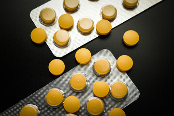 Pills Medicine tablet Brown Yellow in blister pack on a black background