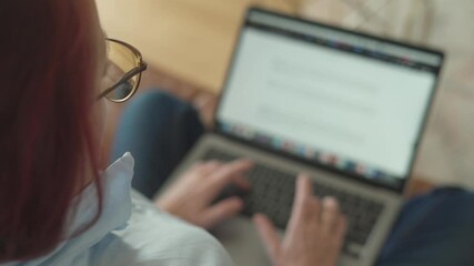 Aufkleber - A focused woman is intently typing on her laptop while comfortably dressed in casual attire from the comfort of her own home, showcasing her dedication and concentration on her tasks