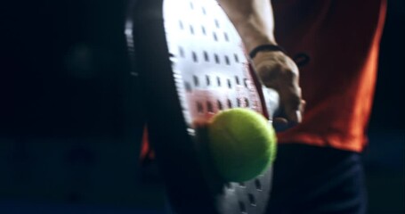 Super slow motion macro of paddle player is hitting ball during competition game match or training workout on indoor court at 1000 fps.