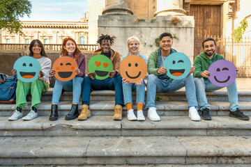 Diverse group of young friends showing social media emotions with colorful emoji signs