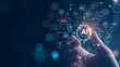 © Wasin Arsasoi - Photo of A hand holding an AI icon with the text AI floating above it, surrounded by digital symbols and icons representing artificial intelligence technology.