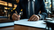 © Alfazet Chronicles - Close-up of a businessman in a suit signing a document at a desk, emphasizing corporate and professional themes. The setting is a modern office with warm lighting.