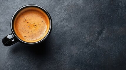 Wall Mural - Top view of an espresso coffee cup on a dark grey background, highlighting the rich texture and color of the espresso. The image captures the essence of espresso with ample copy space.