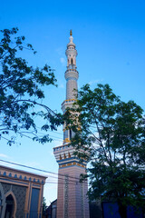 The mosque's minaret rises high against the blue sky, adding to the atmosphere of majesty