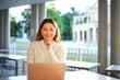 © Austockphoto - Lone woman working on laptop in seated area