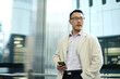 © Austockphoto - Asian businessman wearing cream coat in modern workplace