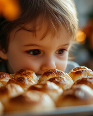 A young child looks intently at a plate of freshly baked pastries