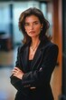 © vefimov - This is a photograph of a young, beautiful professional woman standing confidently with her hands on hips. She is dressed in formal business attire and appears ready for work or meetings.