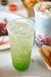 © Austockphoto - Close-up shot of a green soda with sweet treats on the side
